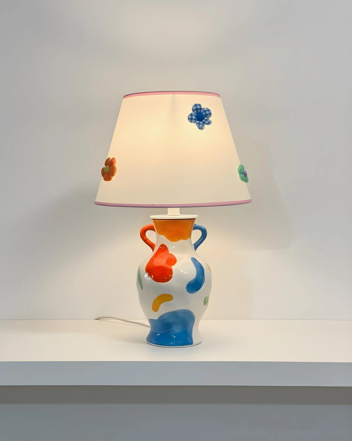 Ceramic table lamp with hand-painted base and decorative floral shade accents, product showcase view
