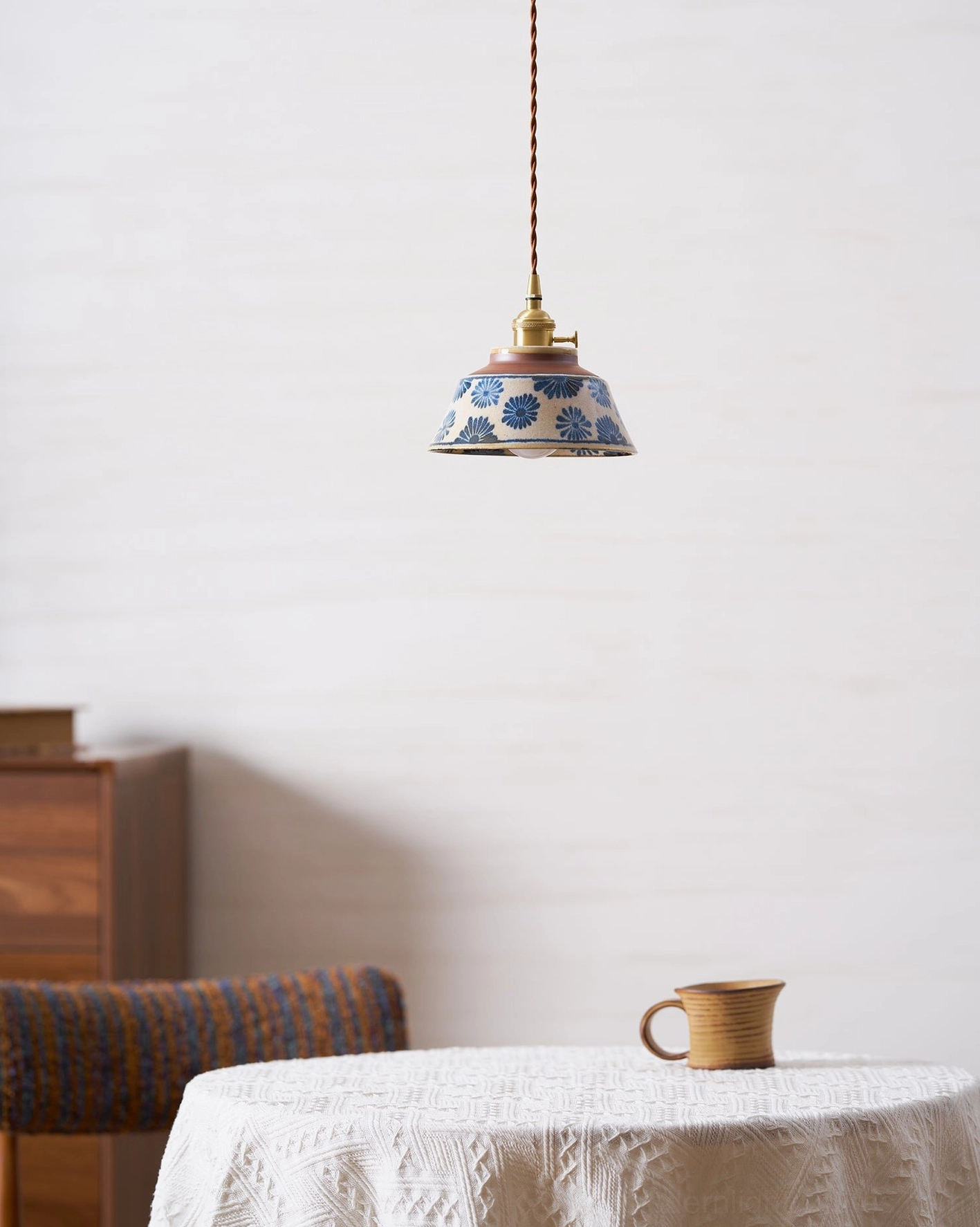 Close-up view of hand-painted blue floral motifs on ceramic pendant light shade surface
