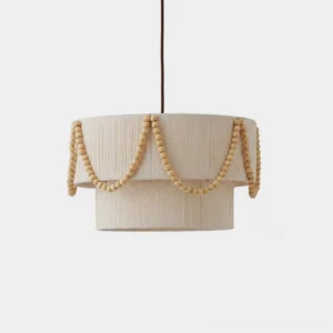 Hand-woven cotton bead pendant light with two-tier drum shade and solid wood bead swags, studio front view