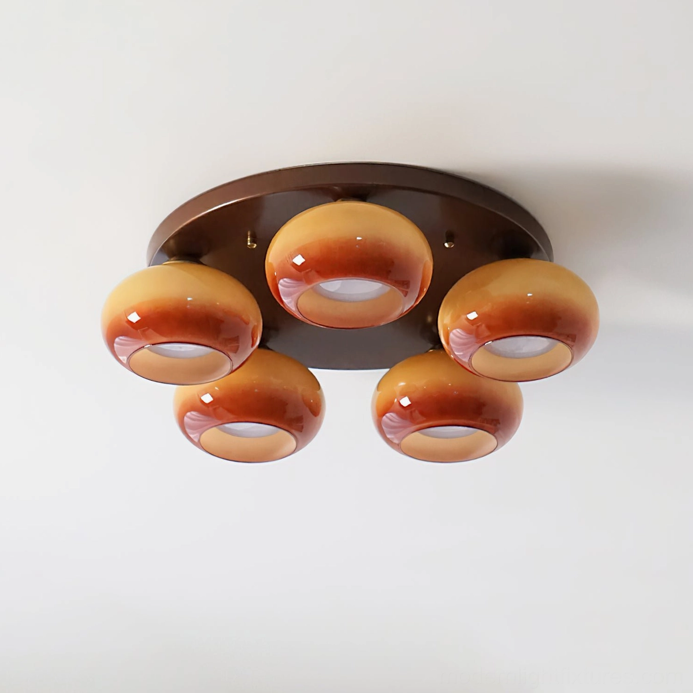 Artisan glass cluster ceiling light with five symmetrically arranged handblown orbs in caramel tones - angled overhead view