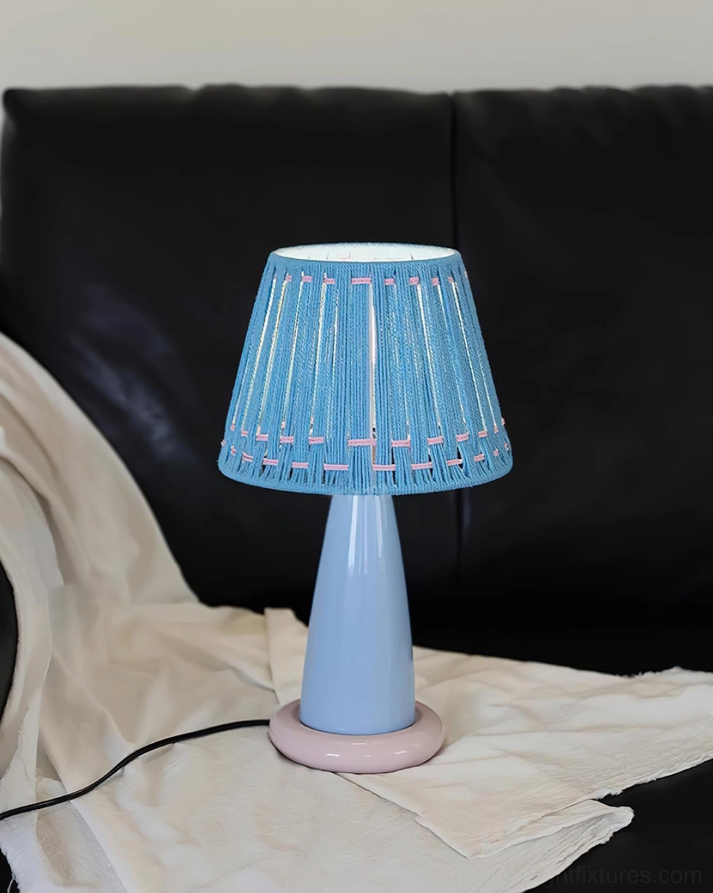 Pastel handcrafted ceramic base table lamp with woven fabric shade, contemporary artisan lighting fixture design