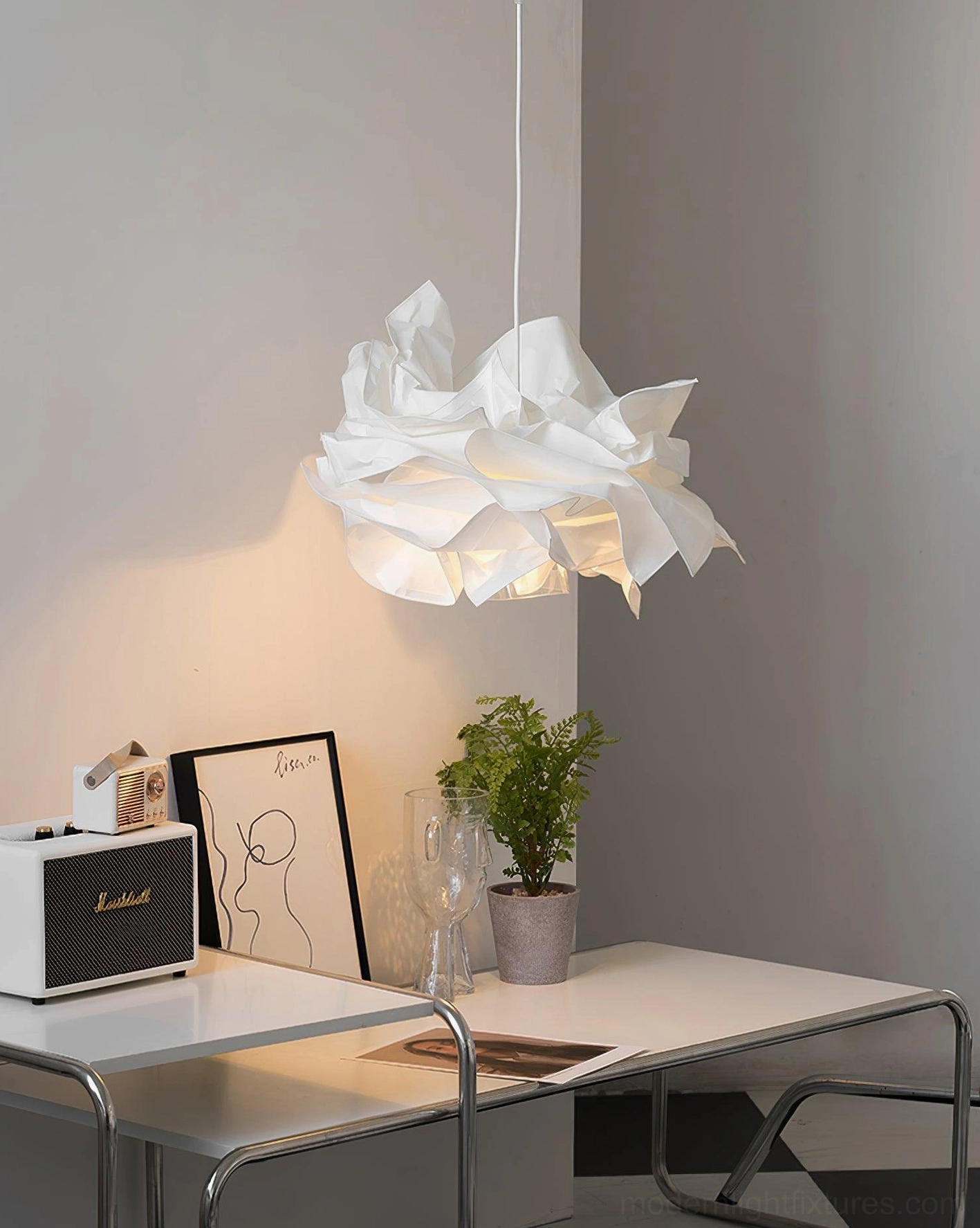 Modern sculptural pendant light above home office desk providing soft warm task lighting