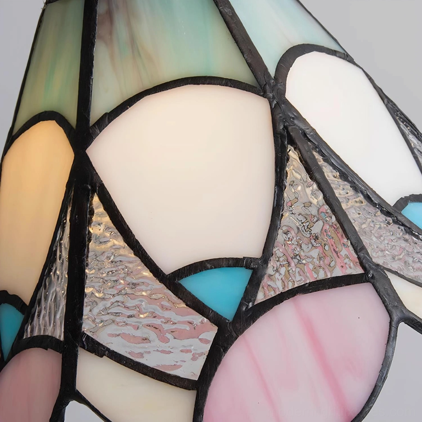 Handcrafted stained glass pendant lamp creating soft colored light in home interior space