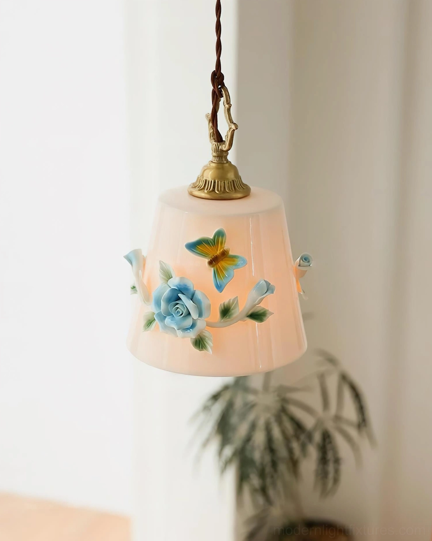 Low angle close-up of handpainted ceramic pendant light with detailed rose and butterfly design, vintage brass fixture details, botanical artistic rendering