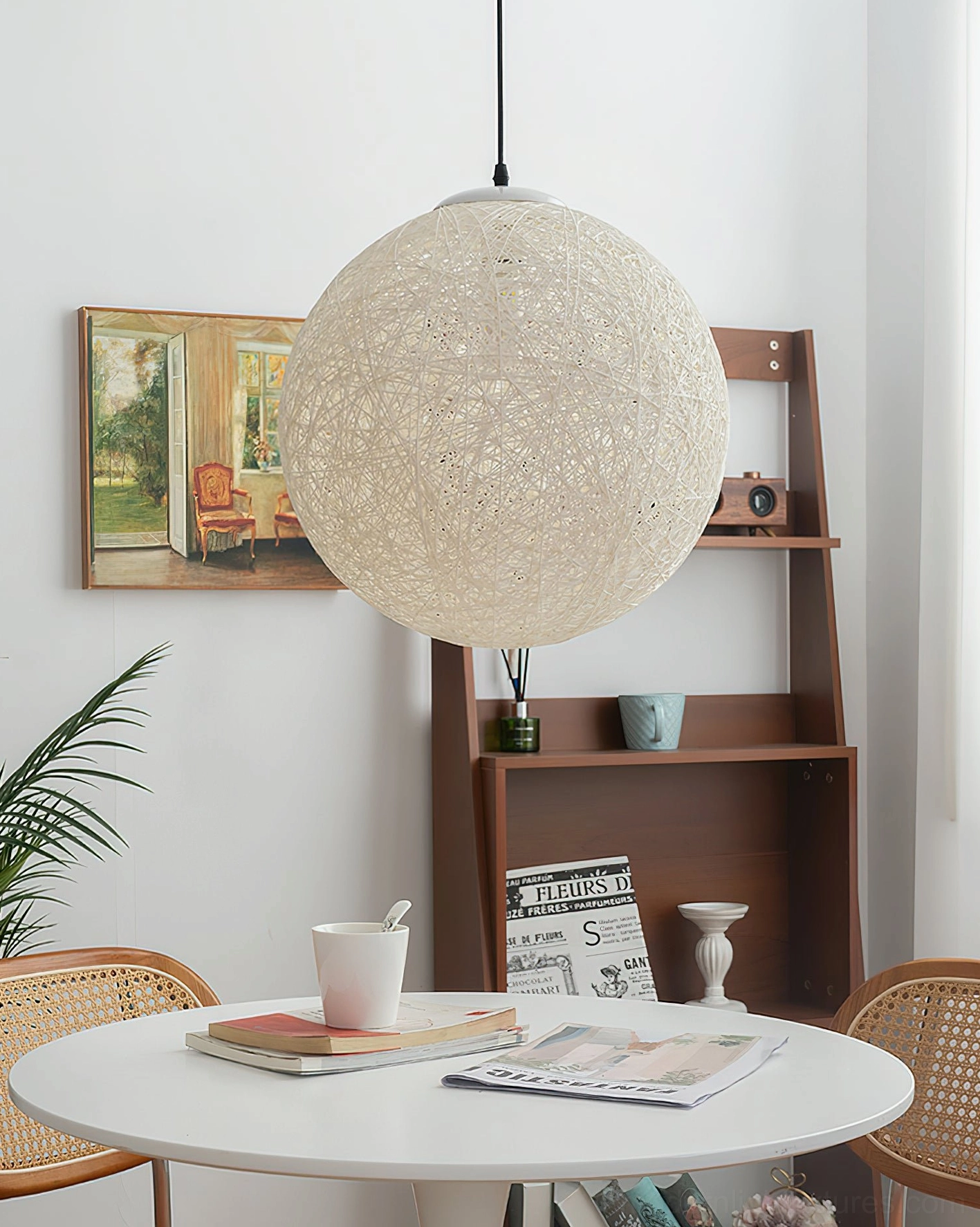 Beige hemp woven sphere pendant light three-quarter angle above dining table with round table and rattan chairs, warm dining ambiance