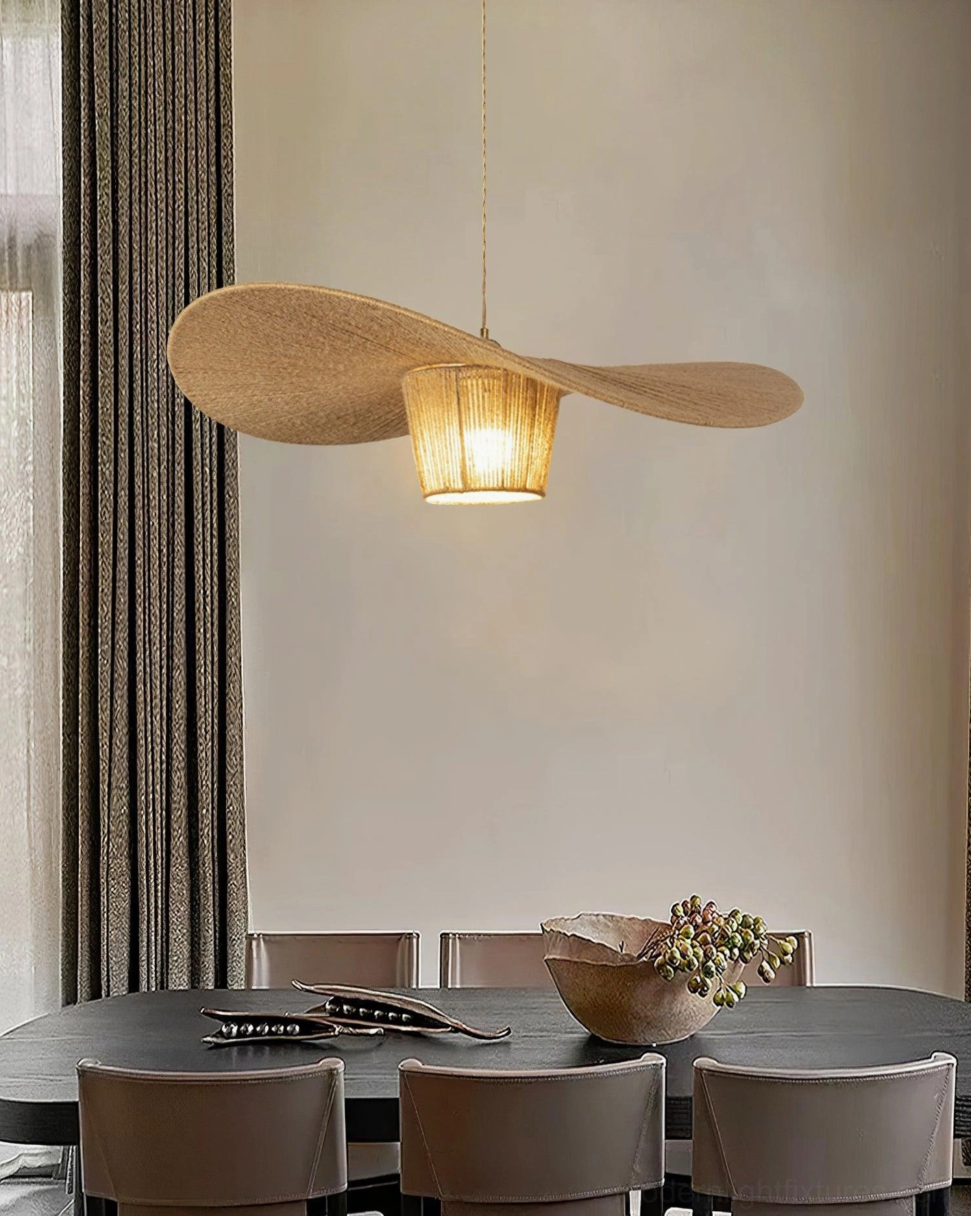 Rustic hemp rope pendant light suspended above dark wooden dining table creating intimate dining ambiance