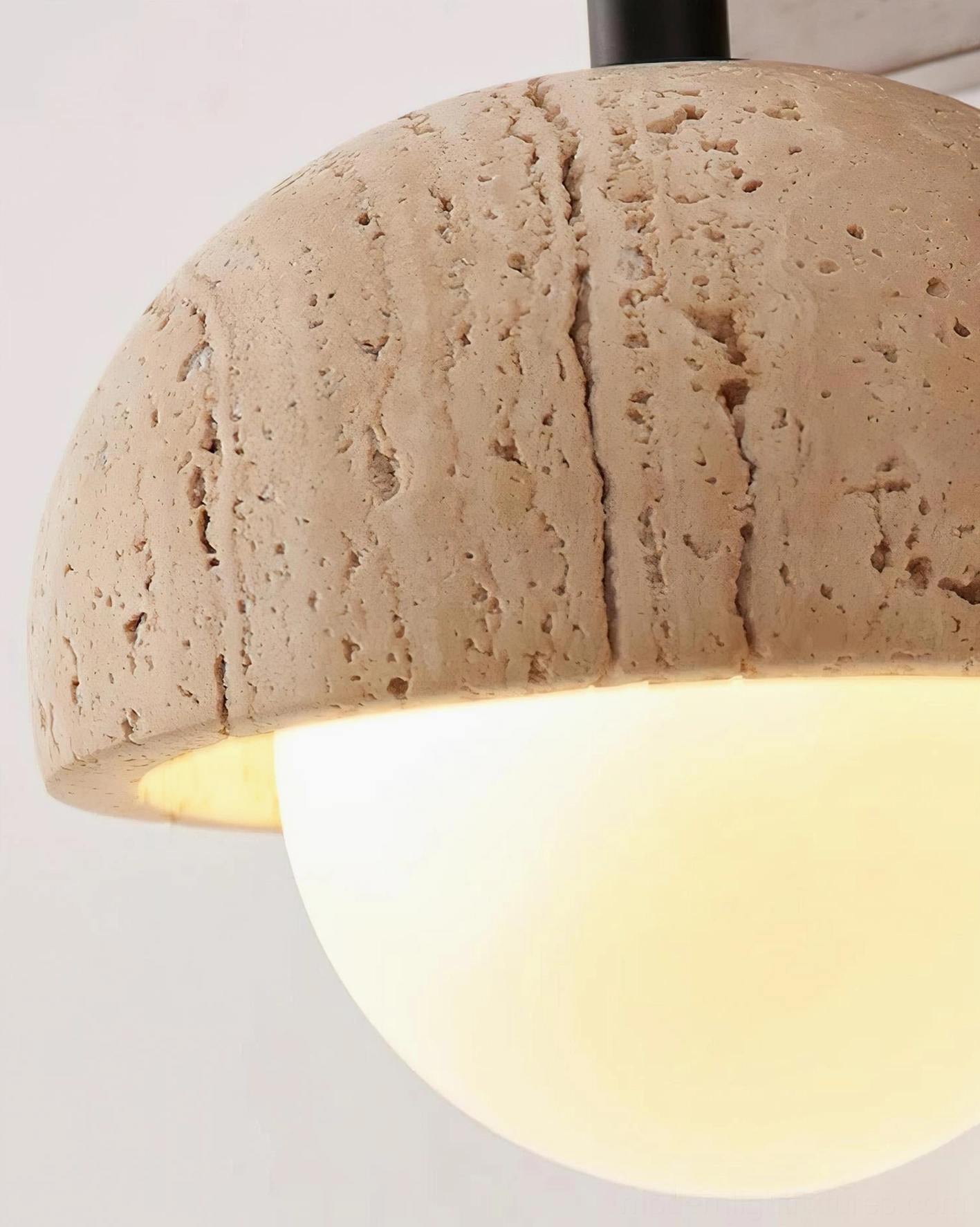 Hardwired travertine wall sconce installation showing mounting hardware and electrical connection