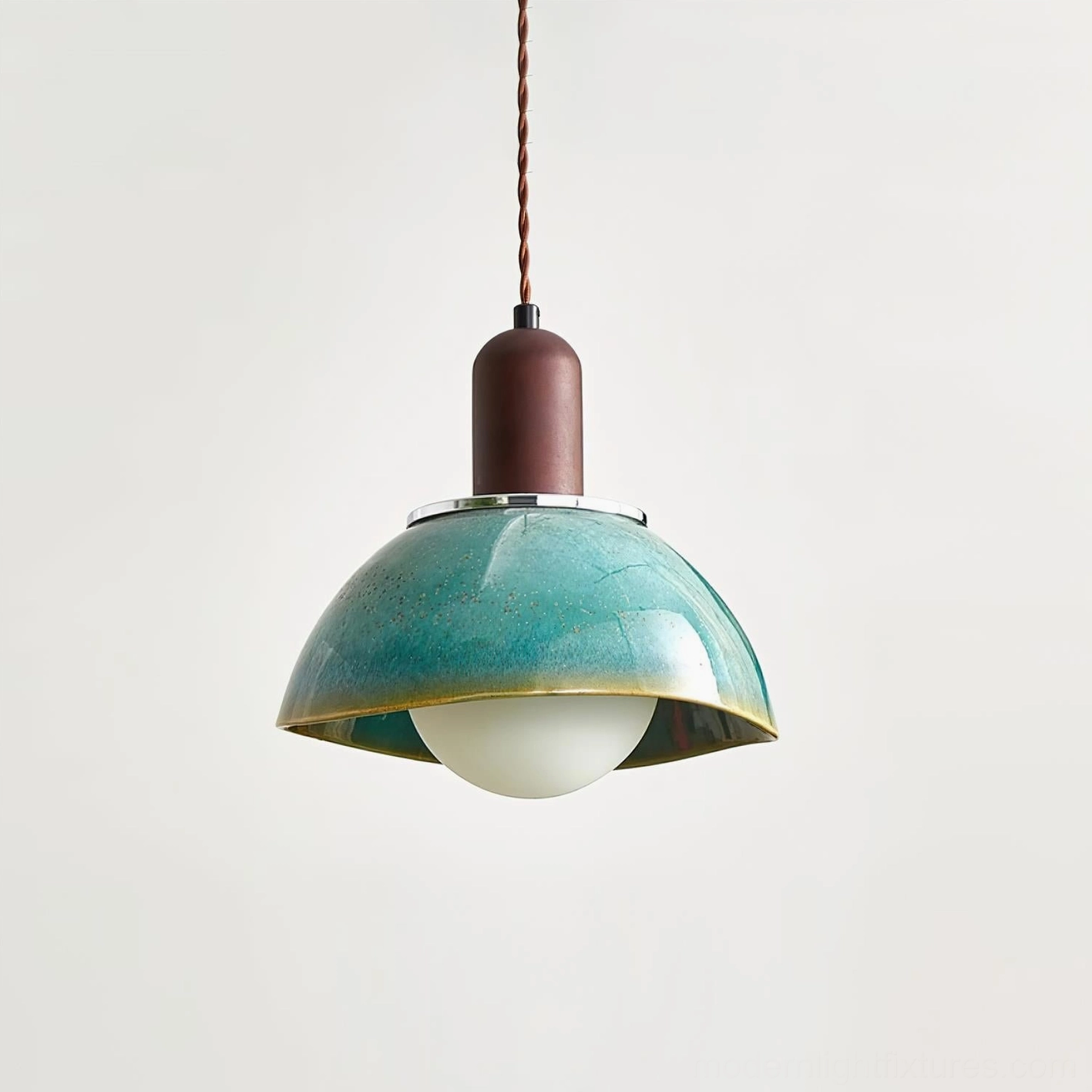 Teal ceramic pendant lamp with frosted bulb and brown twisted hanging cord, low-angle studio photography