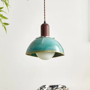 Teal glazed ceramic pendant lamp with frosted spherical bulb, low-angle front view showing speckled finish detail