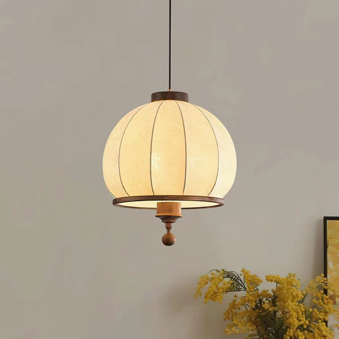 Fabric lantern pendant light with dark wood trim and embossed leaf detail in warm home space
