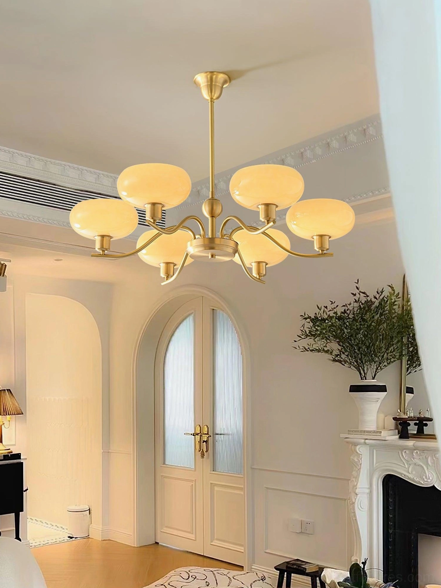 Havana 8-head brass chandelier creating warm illumination in French retro-style living room with fireplace