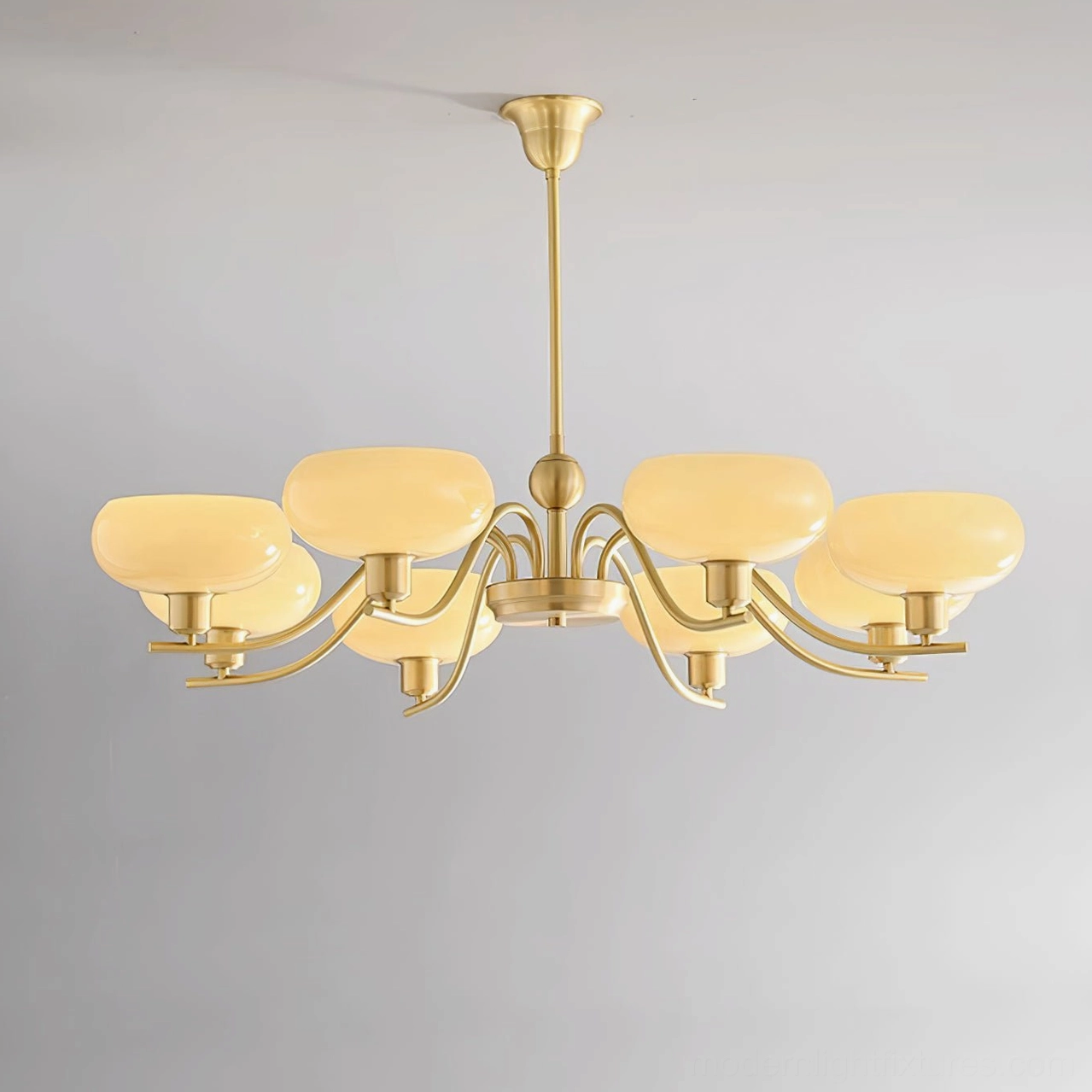 Havana chandelier with warm beige frosted glass spheres suspended from brass frame fixture