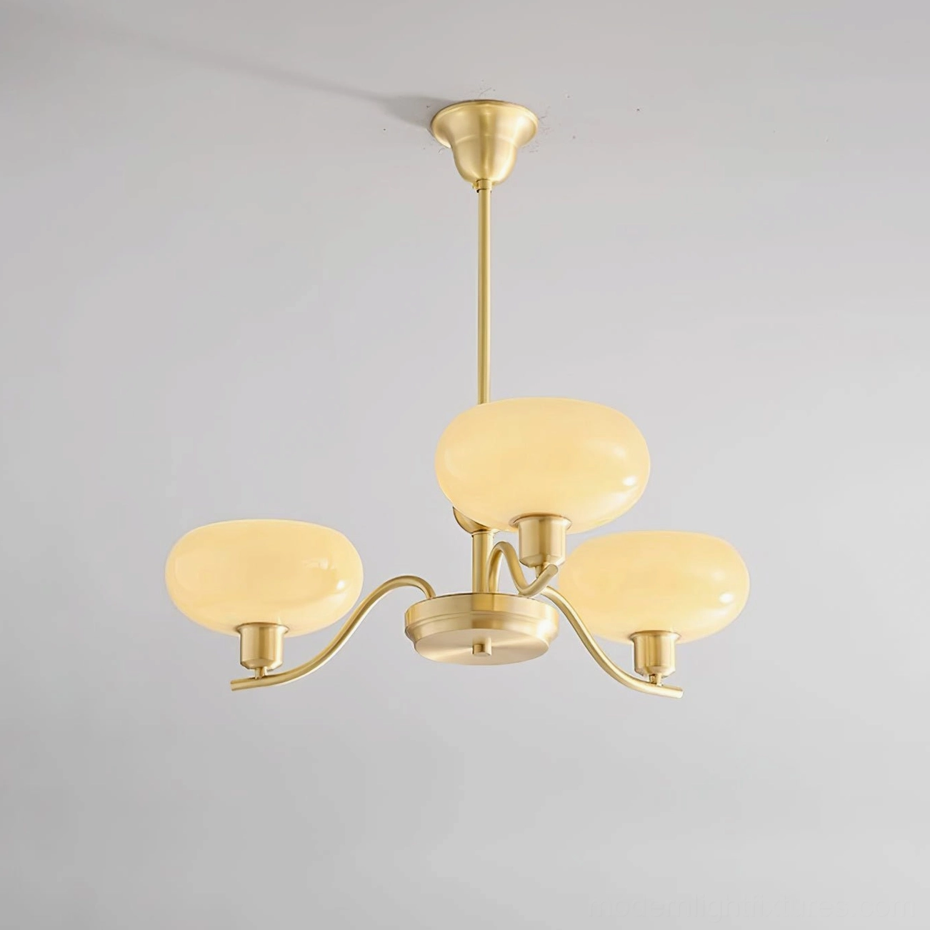 Havana brass chandelier with frosted beige glass globes creating warm ambient room lighting effect