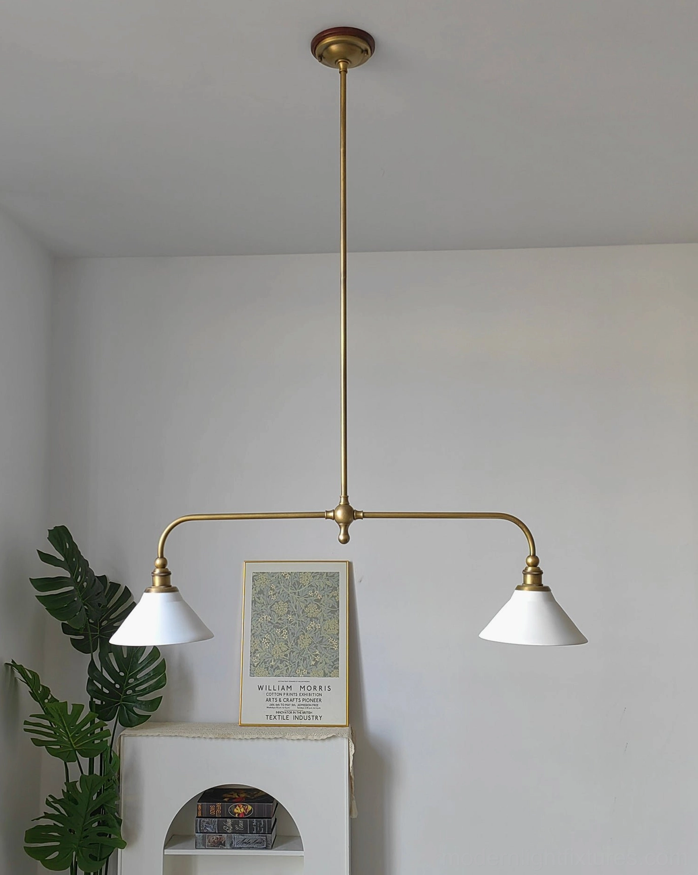 Heirloom-inspired linear pendant fixture with brass construction and white conical shades in mid-century modern dining room