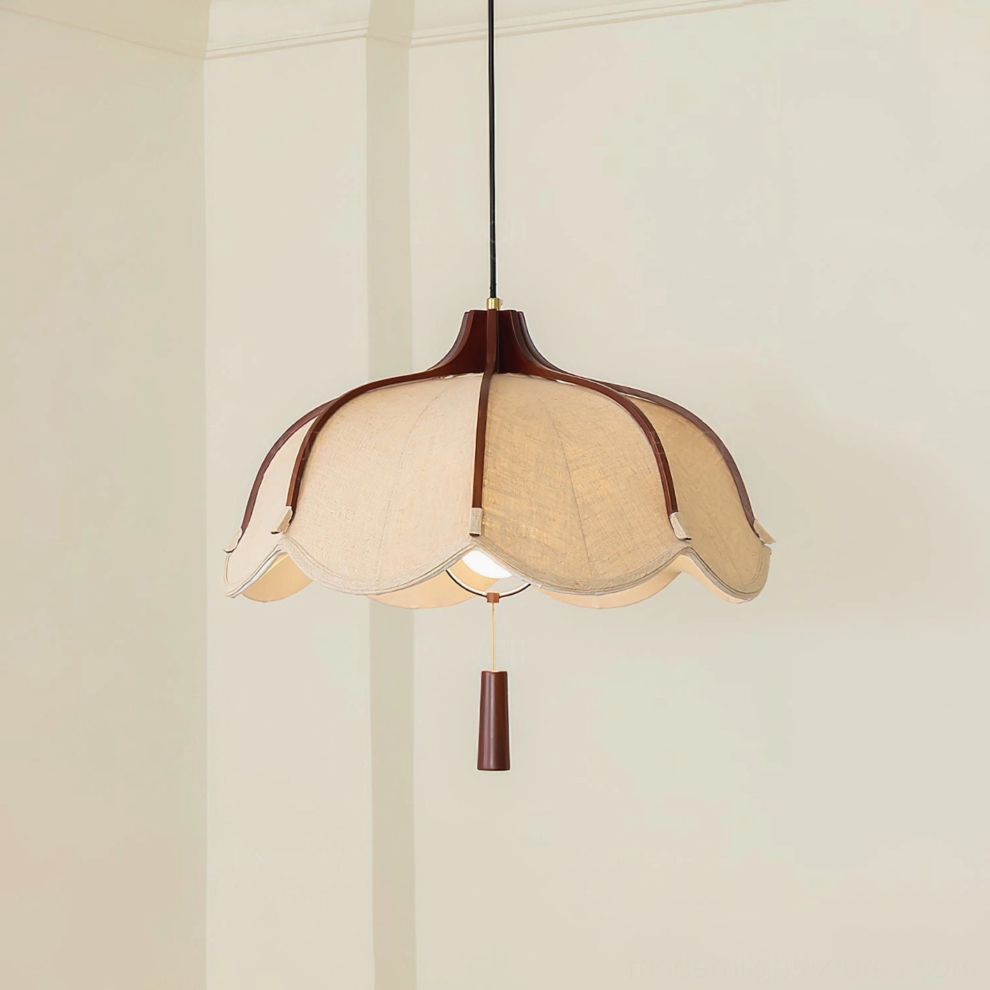Close-up detail of Helia pendant lamp showing scalloped linen shade with dark wood trim and decorative pull tab