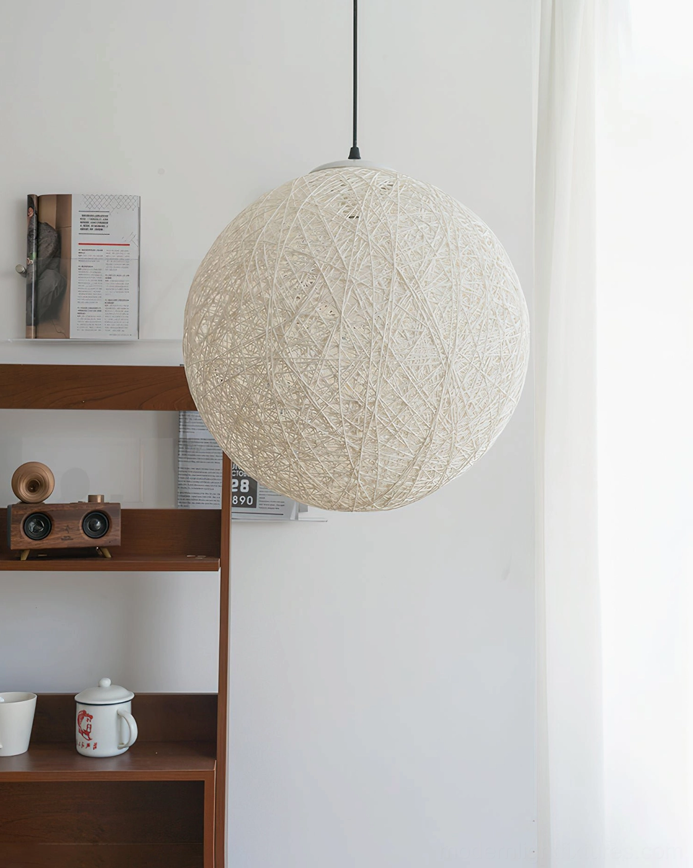 Off-white hemp rattan sphere pendant light front view in minimalist interior with wooden shelf and wall art, bohemian aesthetic