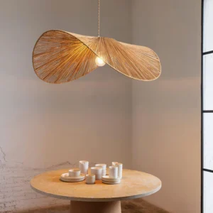 Woven straw hat style pendant light suspended above round wooden dining table in modern residential interior