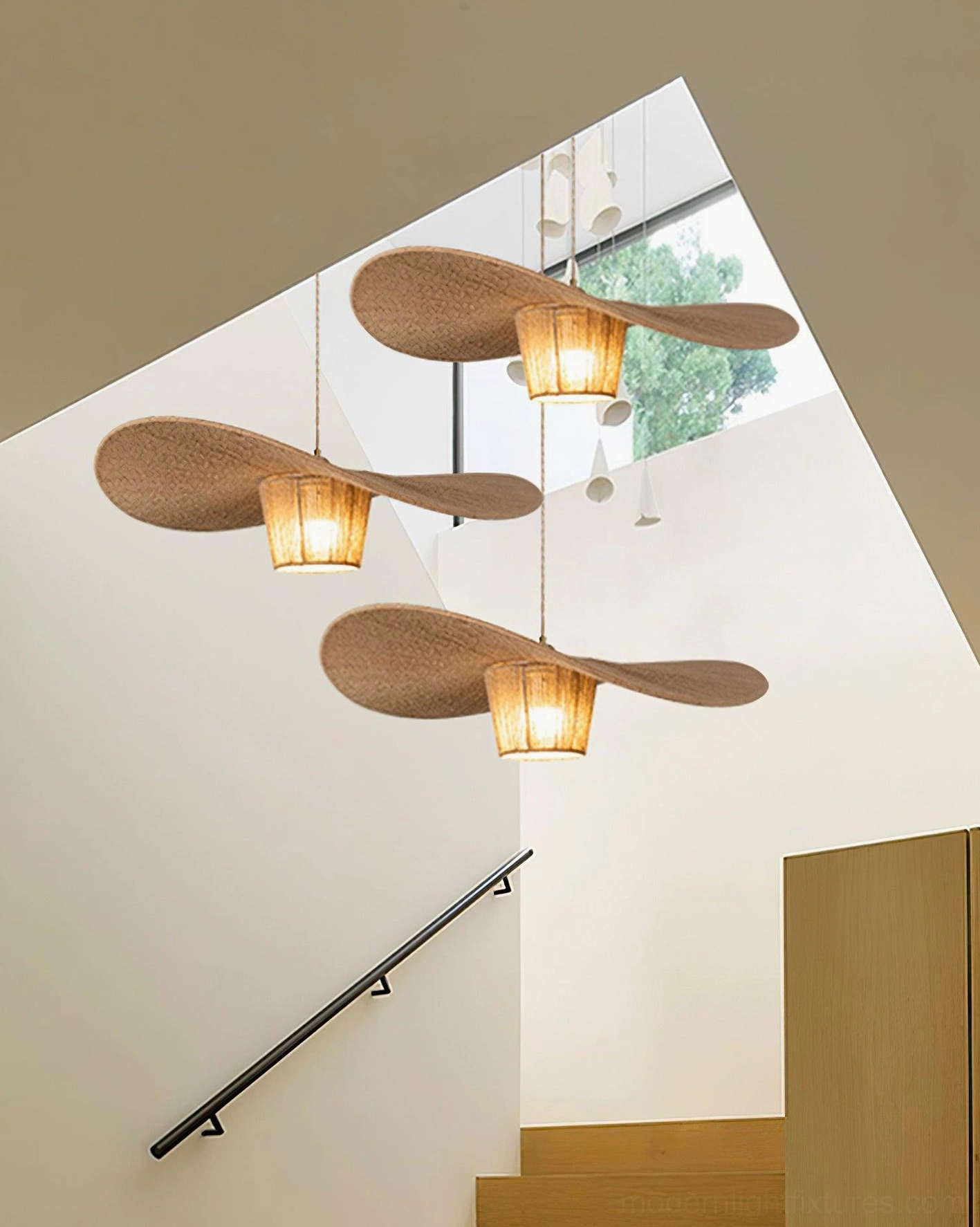Multiple rustic rope pendant lights installed at varying heights in duplex stairwell creating layered ambient lighting