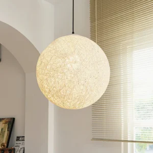 Beige hemp woven pendant lamp three-quarter angle view in residential interior with arched doorway and window blinds, warm ambient lighting