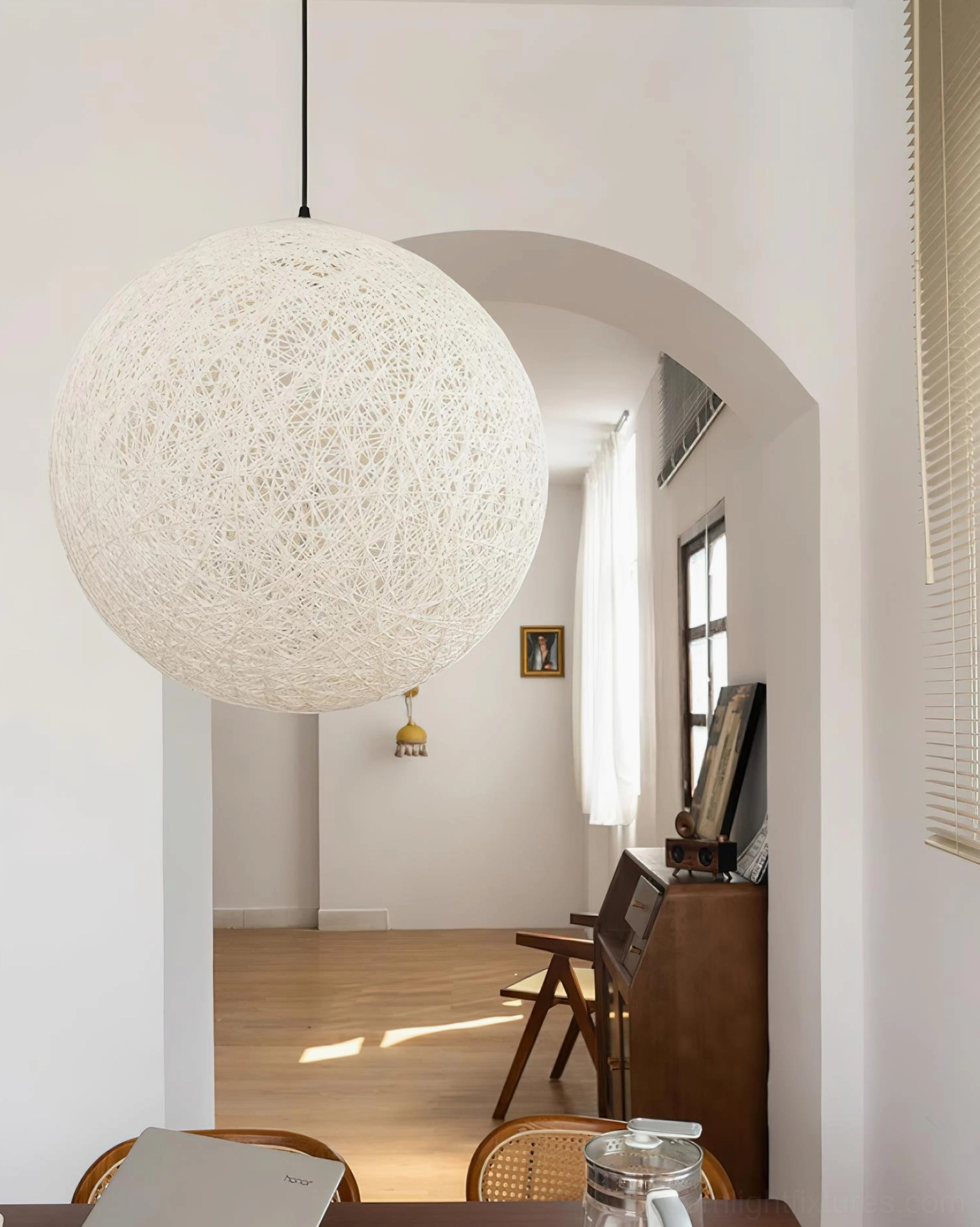 Hemp woven sphere ceiling pendant light installed in modern interior space with multiple ambient lighting sources