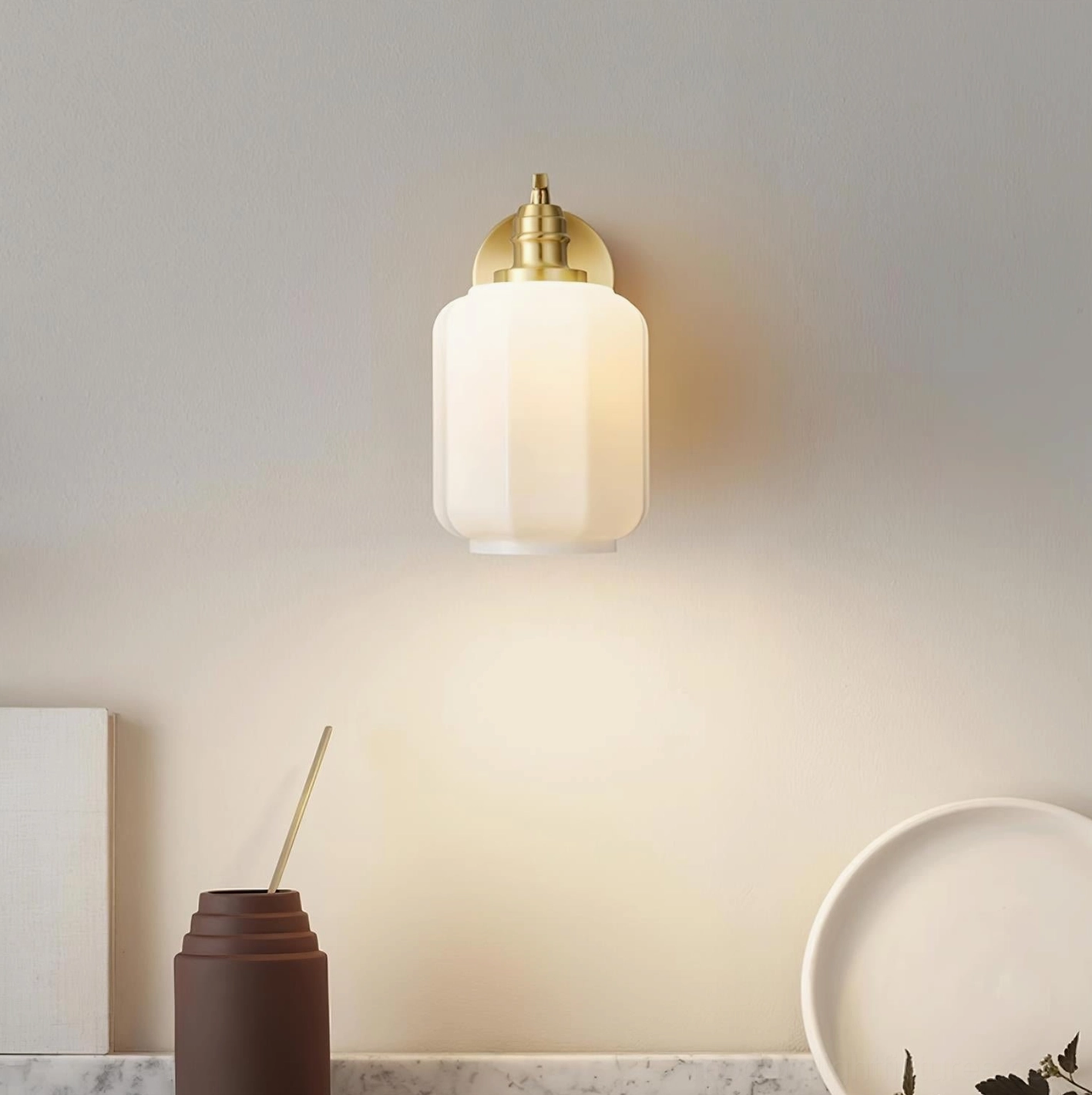 Henry brass wall sconce installed above console table creating sophisticated accent lighting