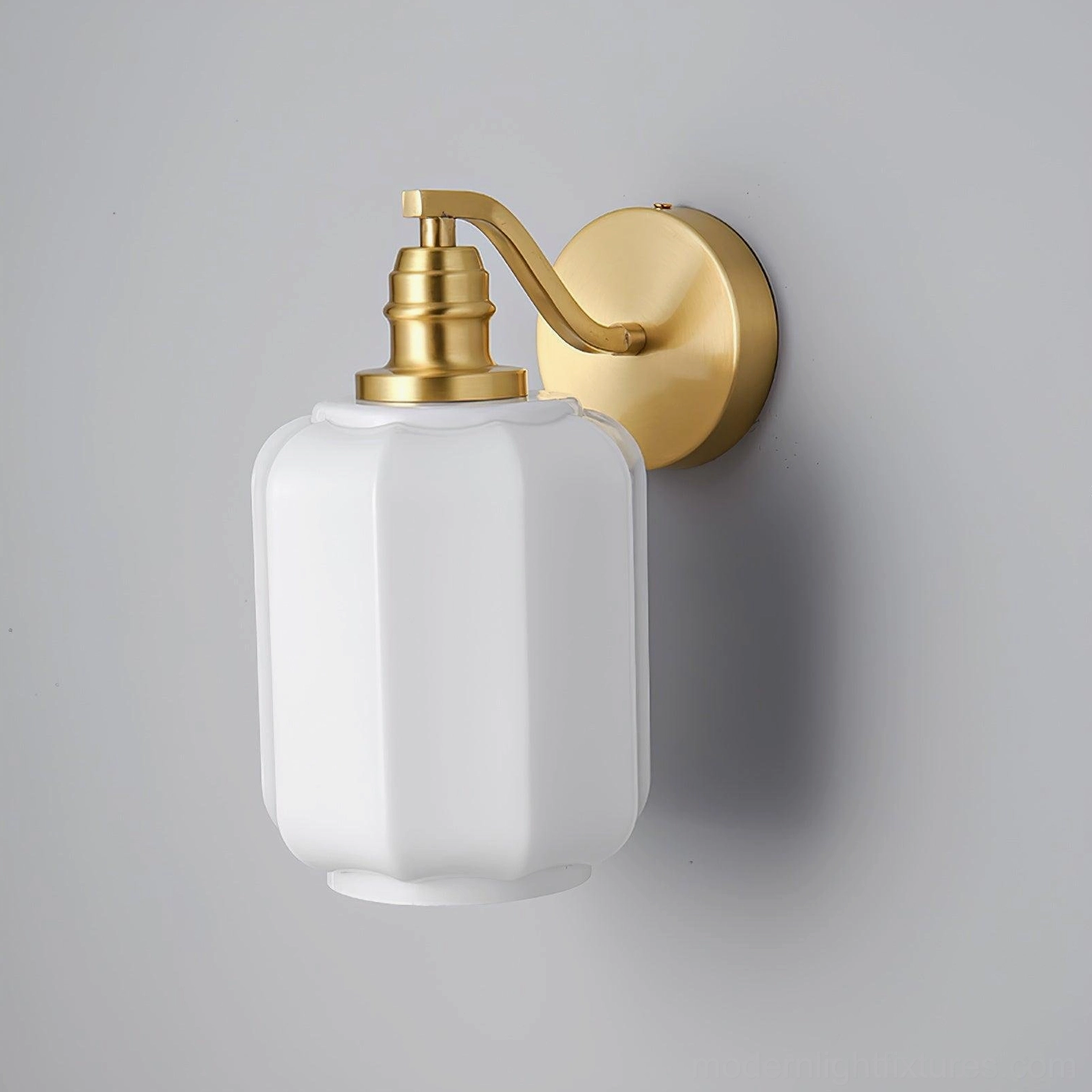 Henry brass wall sconce showing warm light diffusion through frosted glass into ambient downward pool