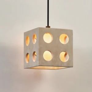 Modern cube pendant light three-quarter angle showing perforated geometric design, travertine material with glowing warm interior