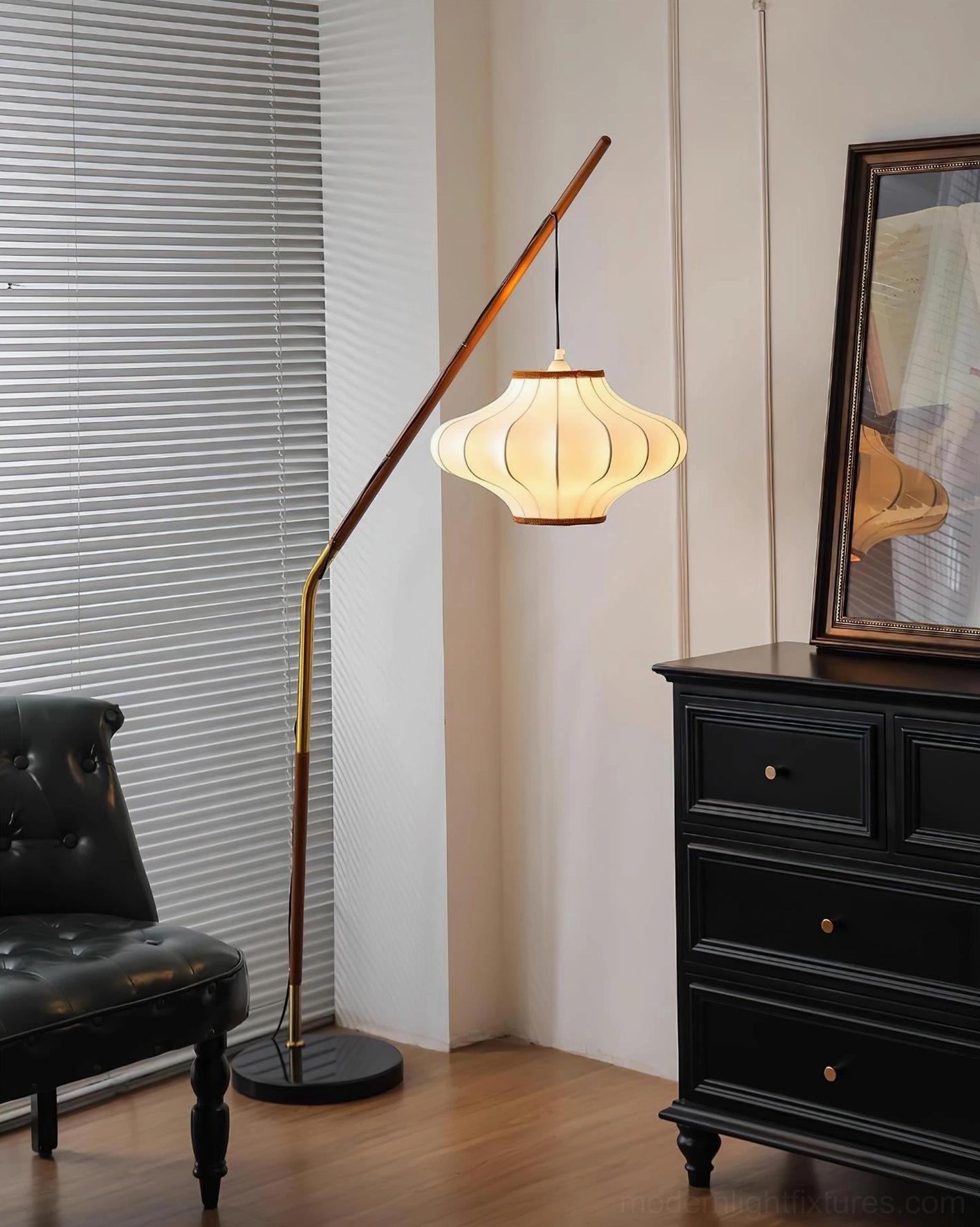 Illuminated Hikari arc floor lamp with soft warm glow from pleated fabric shade in contemporary interior