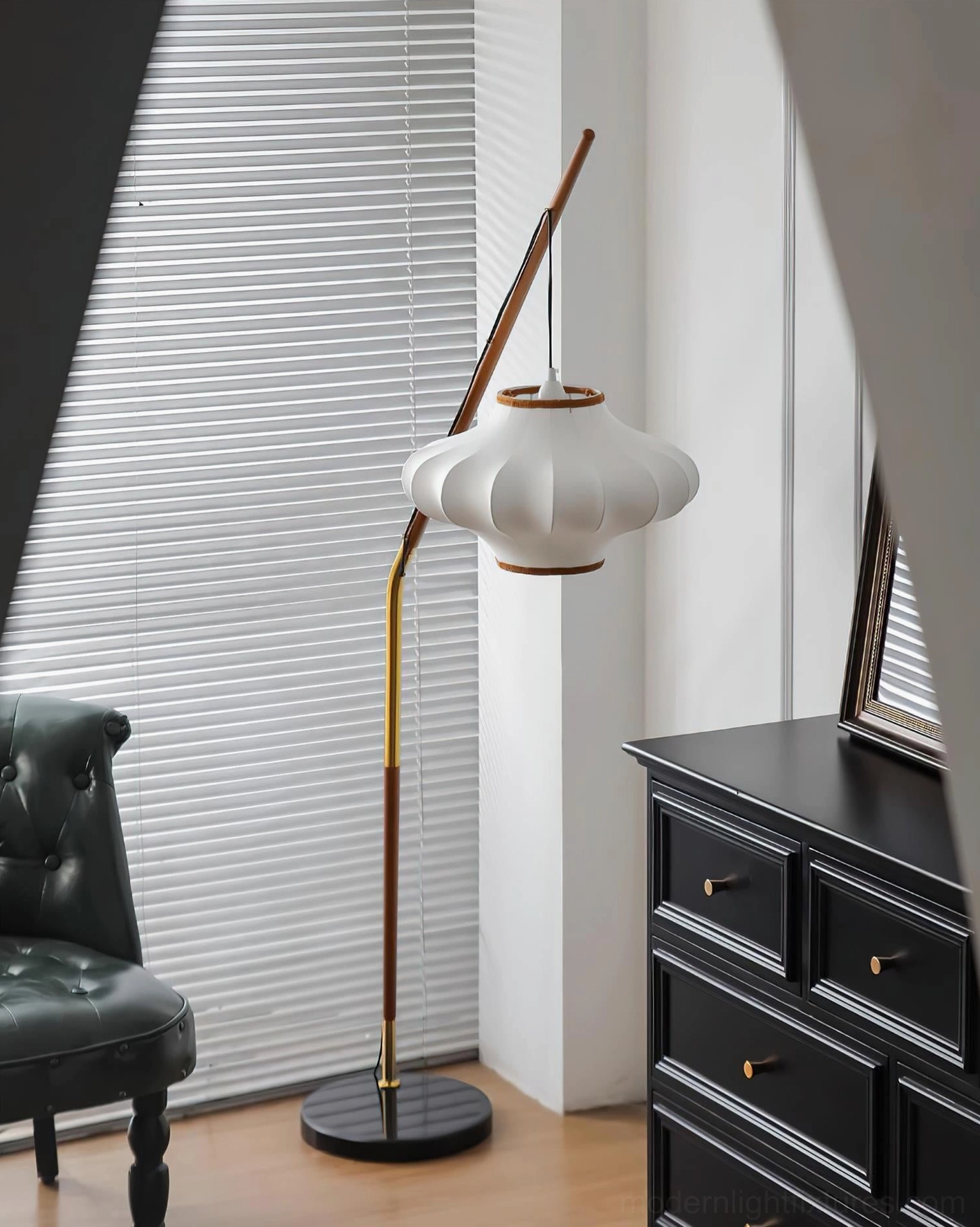 Sculptural arc floor lamp with white pleated shade and dark marble base in contemporary living space