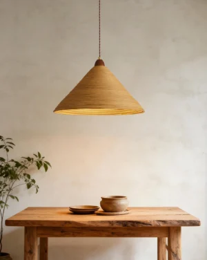 Cone-shaped rattan pendant hanging above rustic dining table in warm wabi-sabi interior setting