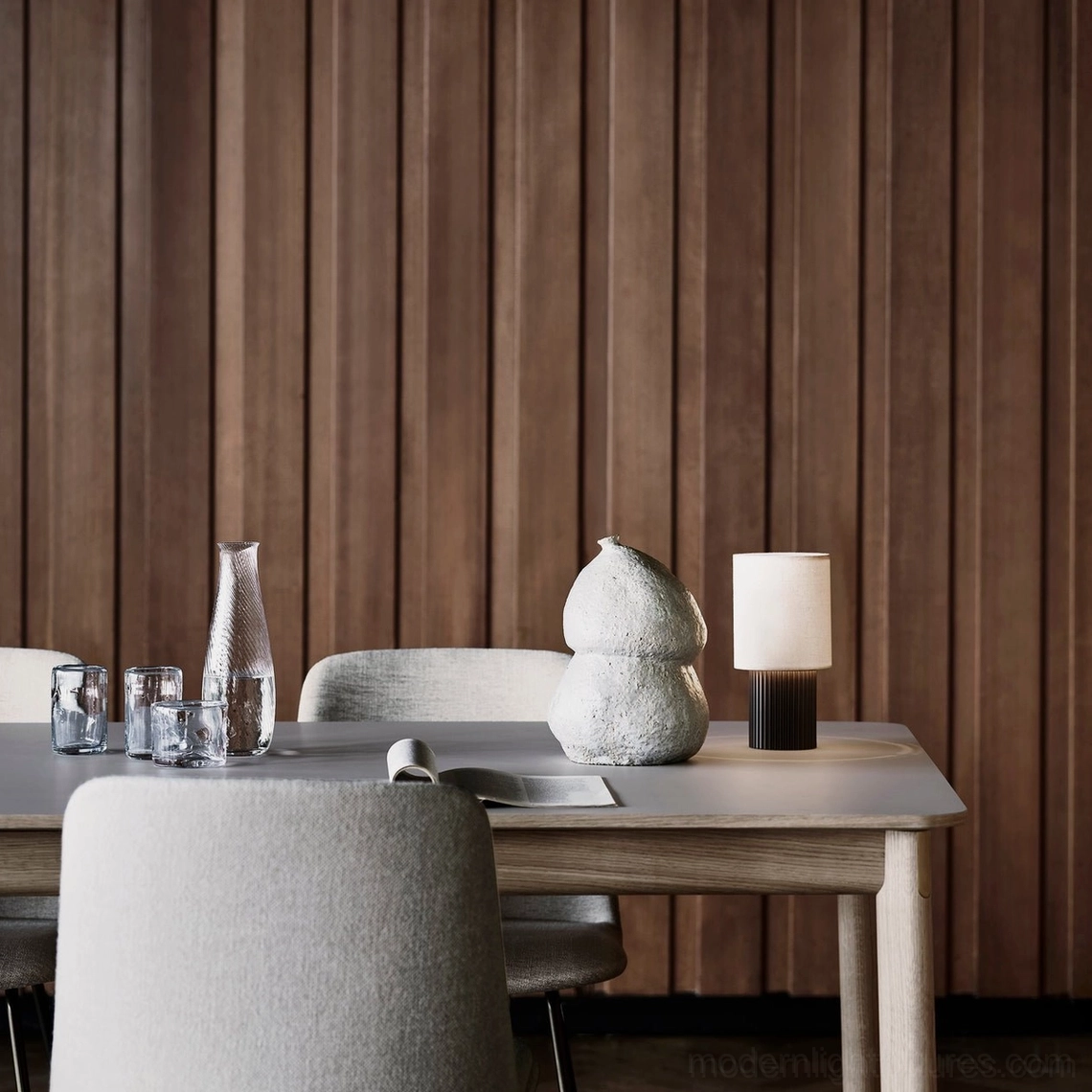Contemporary wireless charging table lamp on wooden desk with wood panel wall, modern minimalist home office three-quarter view