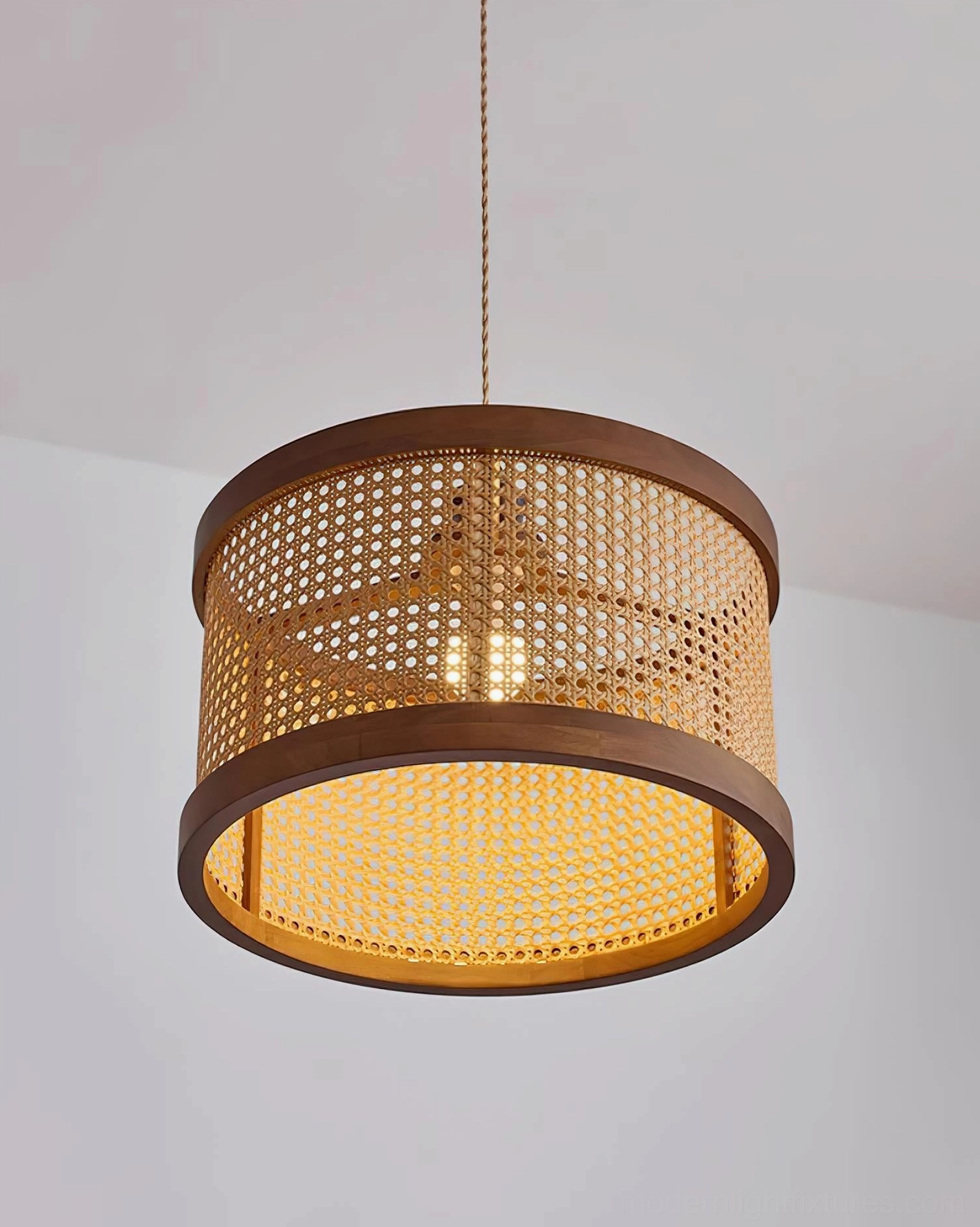 Hoopa rattan pendant lamp illuminated showing internal bulb and downward light diffusion