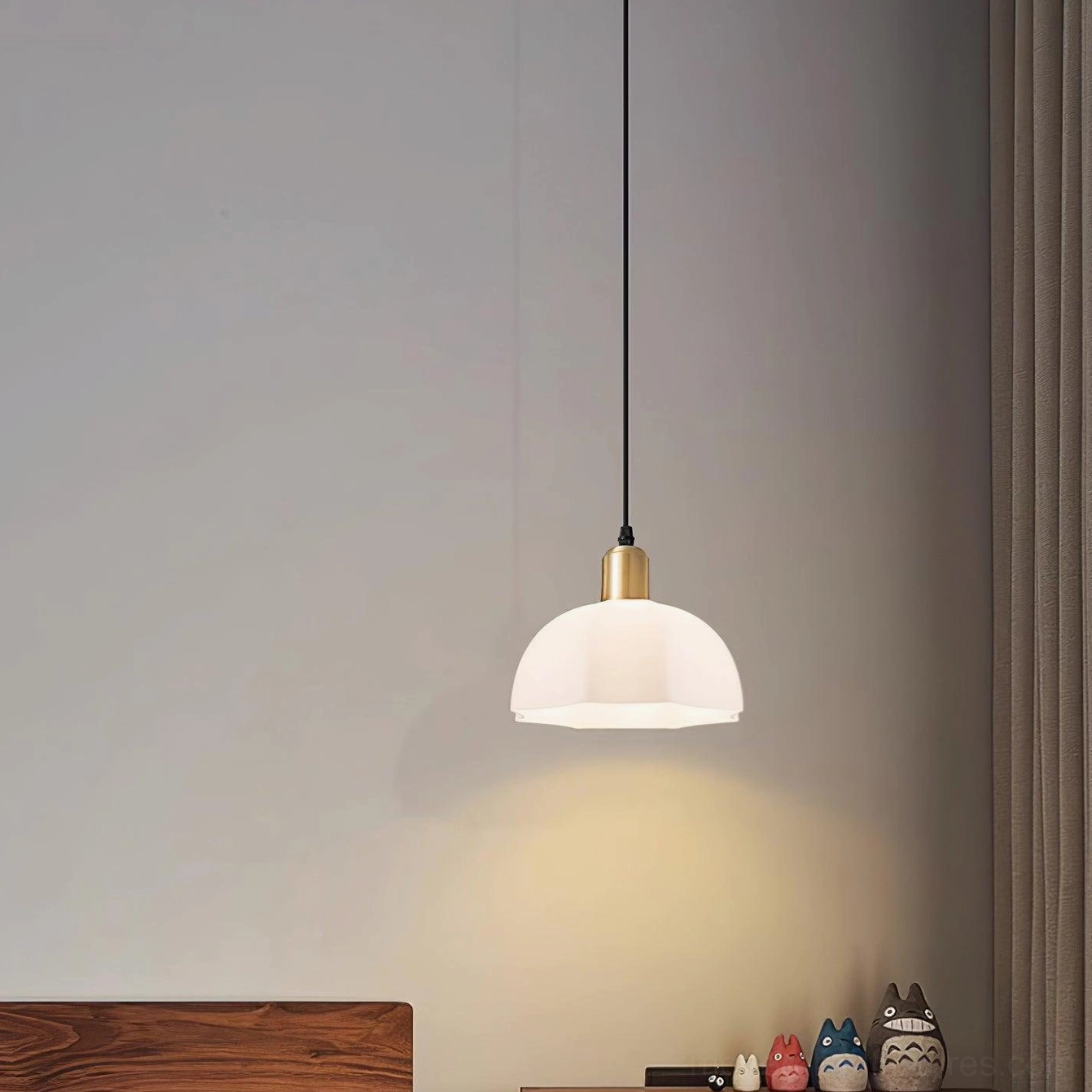 Low frontal view of horn pendant light in bedroom corner with decorative figurines shelf
