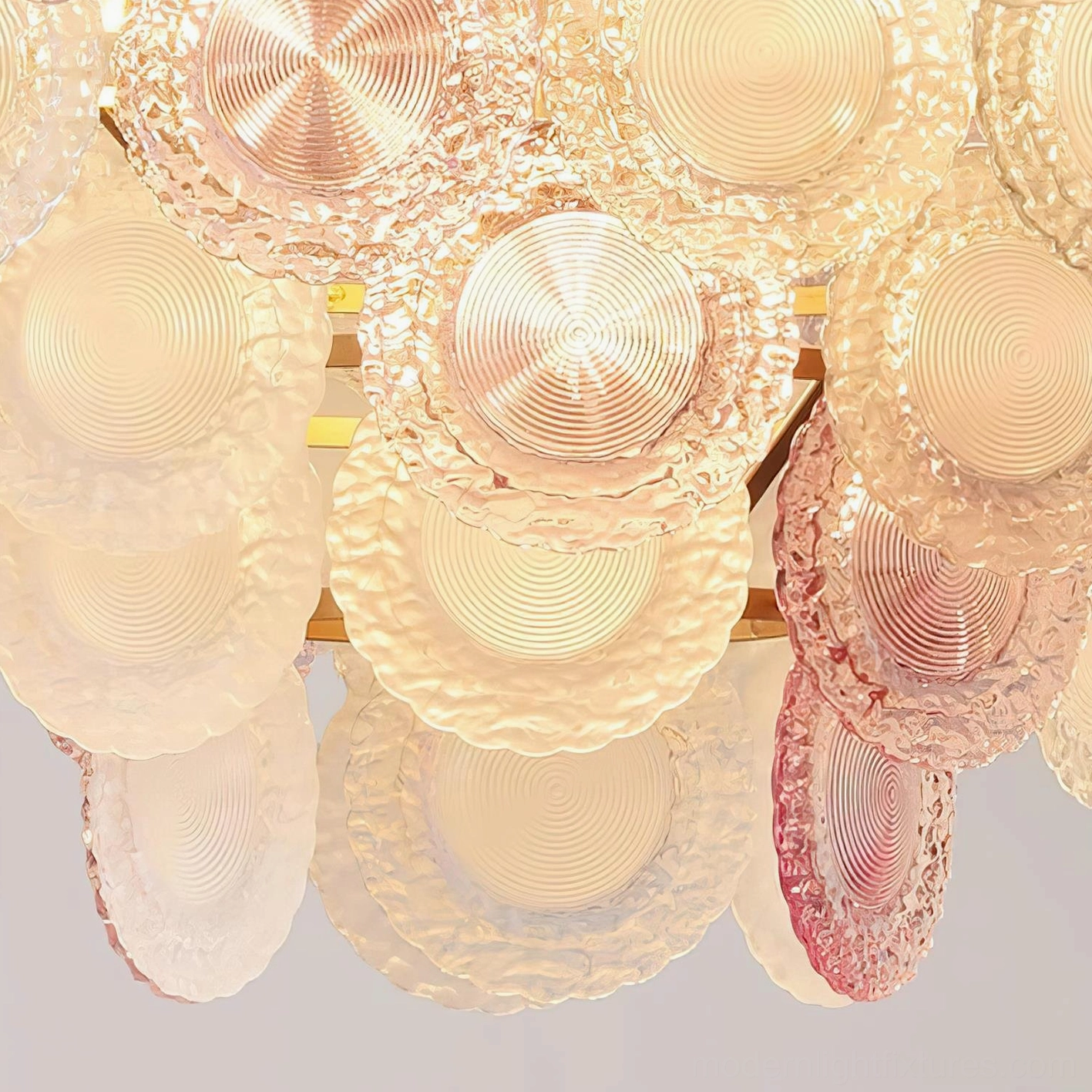 Violaire blush pink glass chandelier illuminated showcasing warm light diffusion through textured glass layers