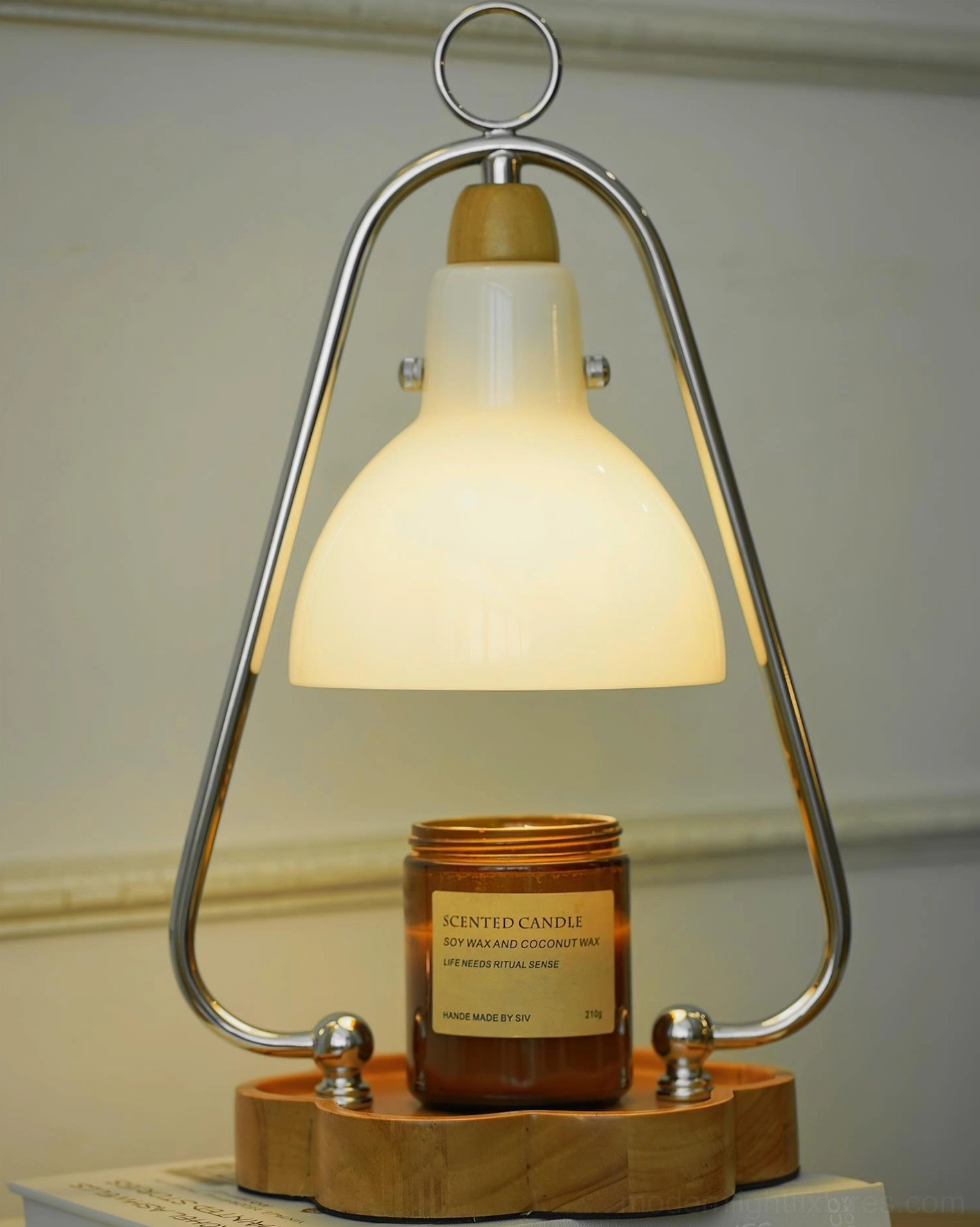 Lit candle warmer lamp with scented candle showing warm glow and illuminated glass shade