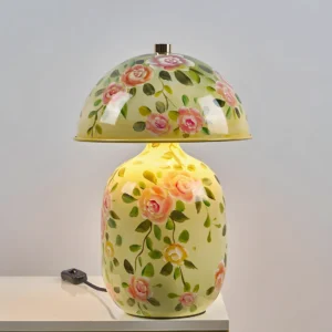Illuminated warm LED table lamp with soft yellow hand-painted ceramic shade in bedroom setting