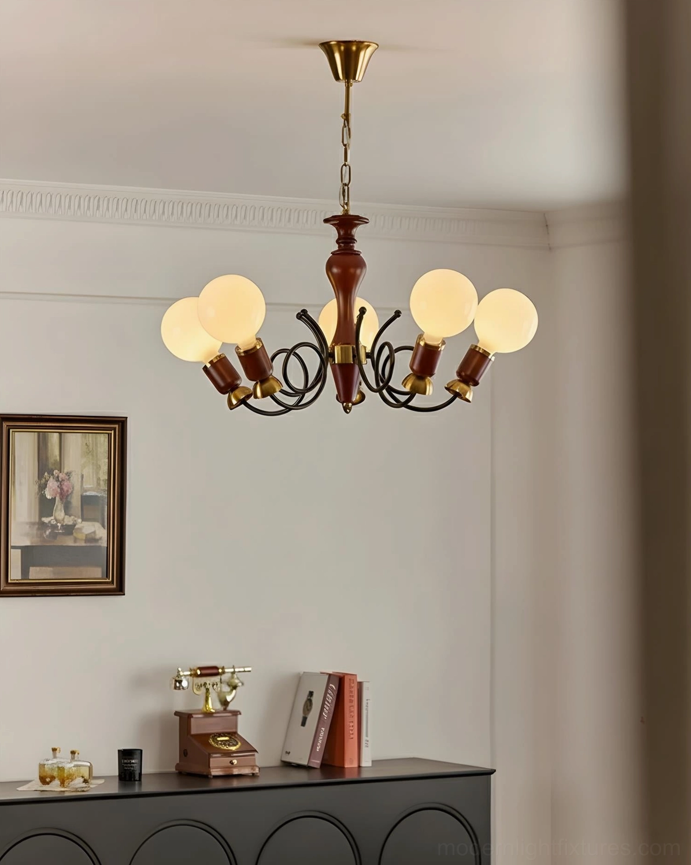 Lit mid-century modern cluster chandelier in retro entryway with dark sideboard and framed art