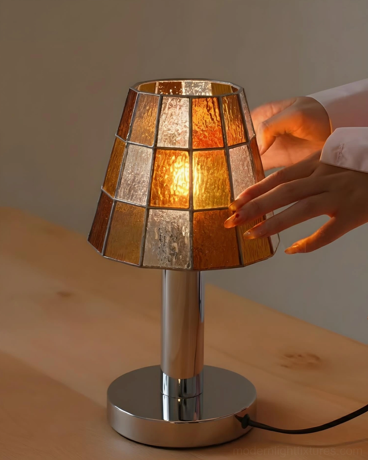 Warm stained glass table lamp with hand interaction, illuminated on home tabletop creating colorful light reflection