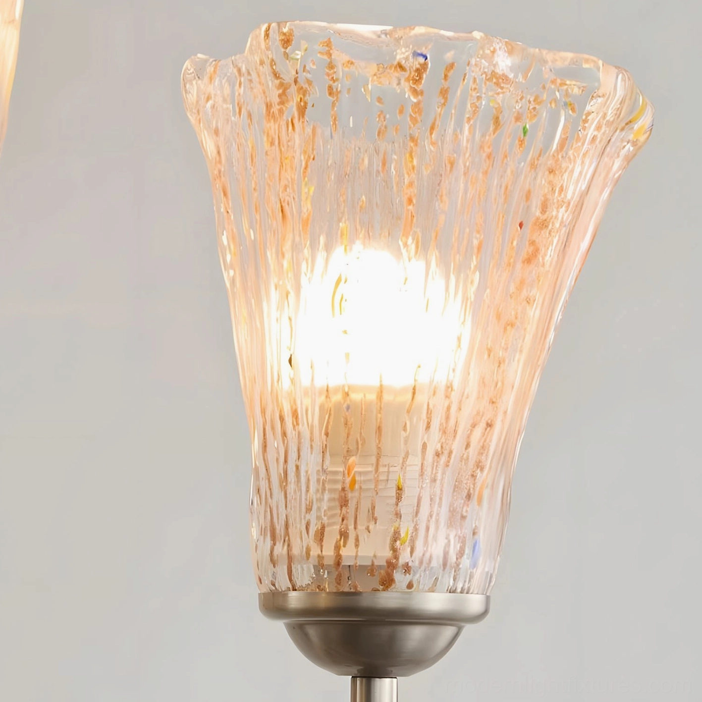 Illuminated Chandelier Glass Shade Close-up - Textured Fluted Clear Glass with Gold Inclusions and Warm Light