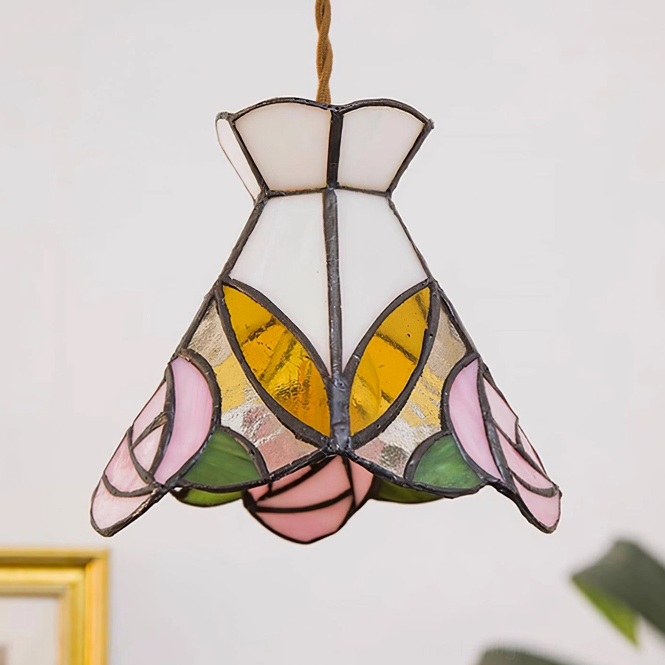 Illuminated Tiffany rose pendant lamp casting warm light through stained glass rose and leaf pattern