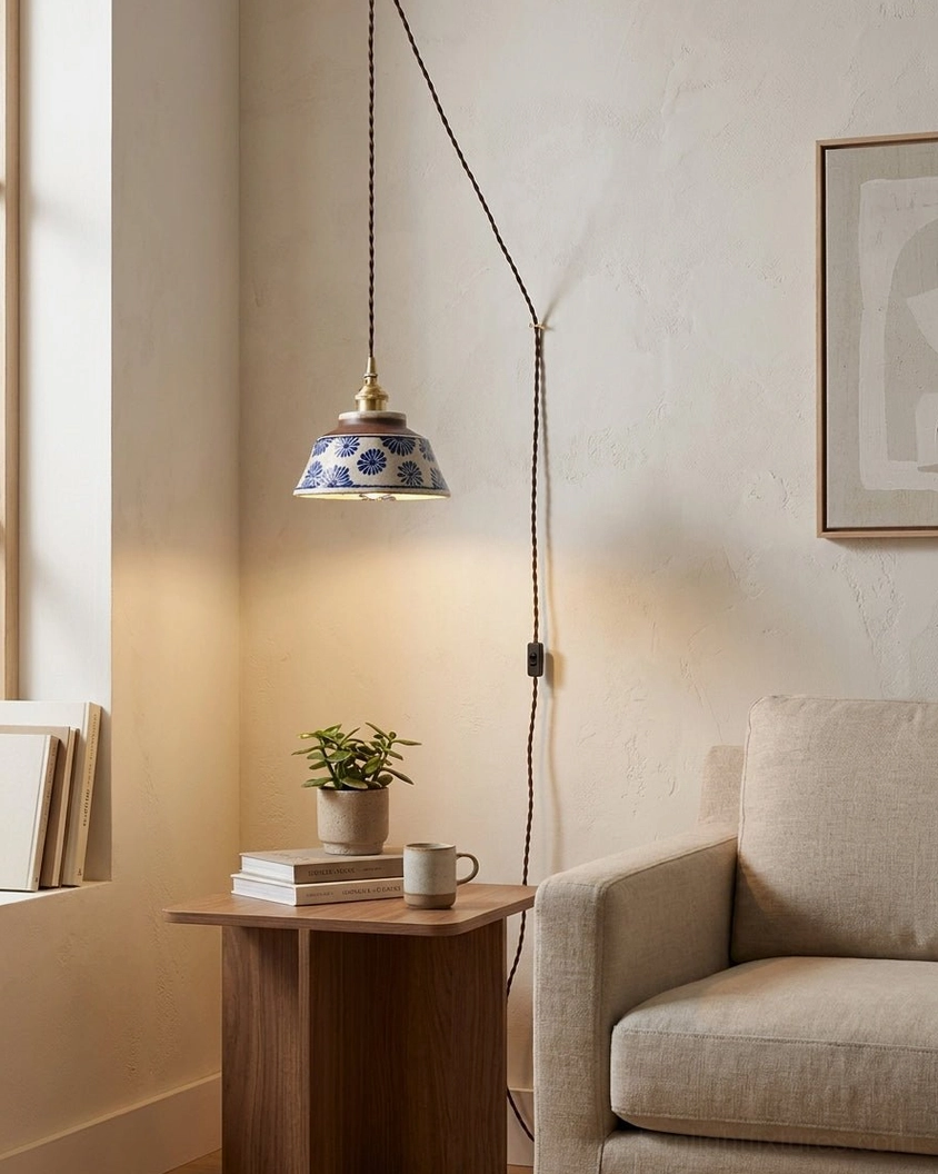 Hand-glazed indigo ceramic floral pendant light in minimalist reading nook corner armchair setting