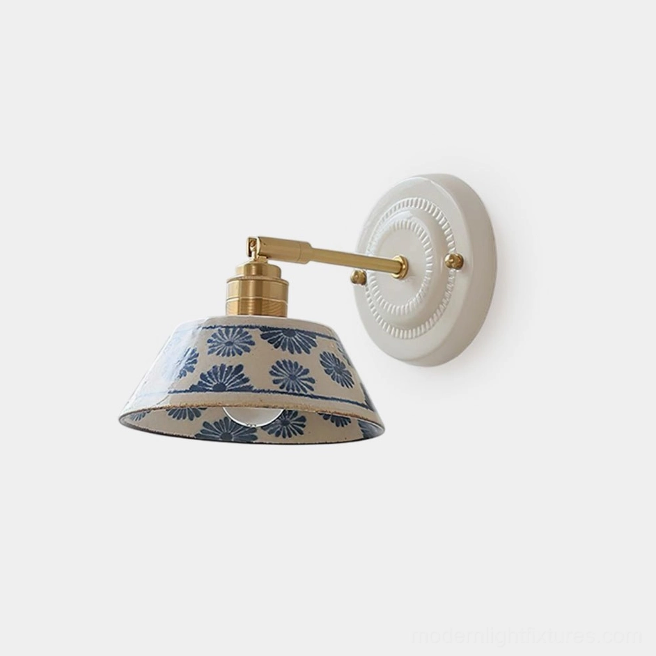 Hand-glazed indigo porcelain wall sconce with brass hardware and white ceramic base, left front view