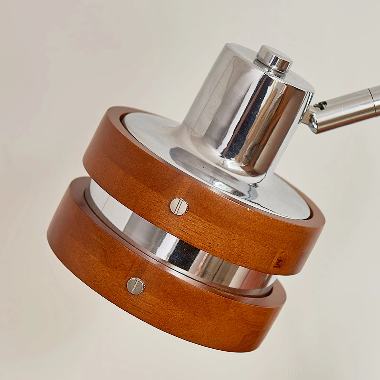 Close-up detail of modern table lamp showing chrome socket and layered wood barrel shade with fastening mechanism