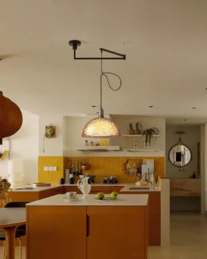 Adjustable swing arm pendant fixture in modern kitchen dining area with warm lighting and minimalist interior design