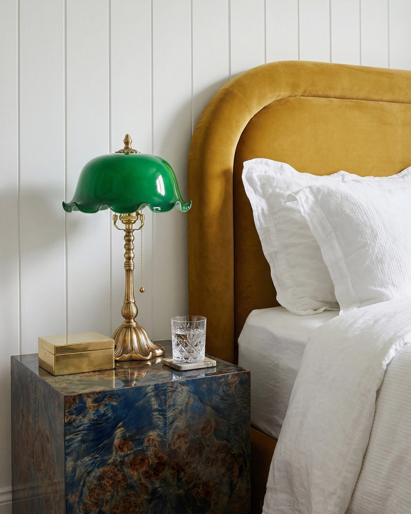Jadelle vintage brass lamp on marble side table in master bedroom with tufted bed