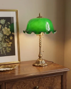 Jadelle Art Nouveau table lamp on wooden dresser with botanical wall art and warm bedroom lighting