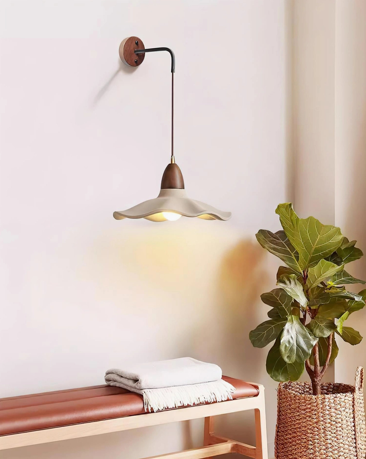 Contemporary wall sconce in neutral entryway nook with potted plant and natural linen accessories