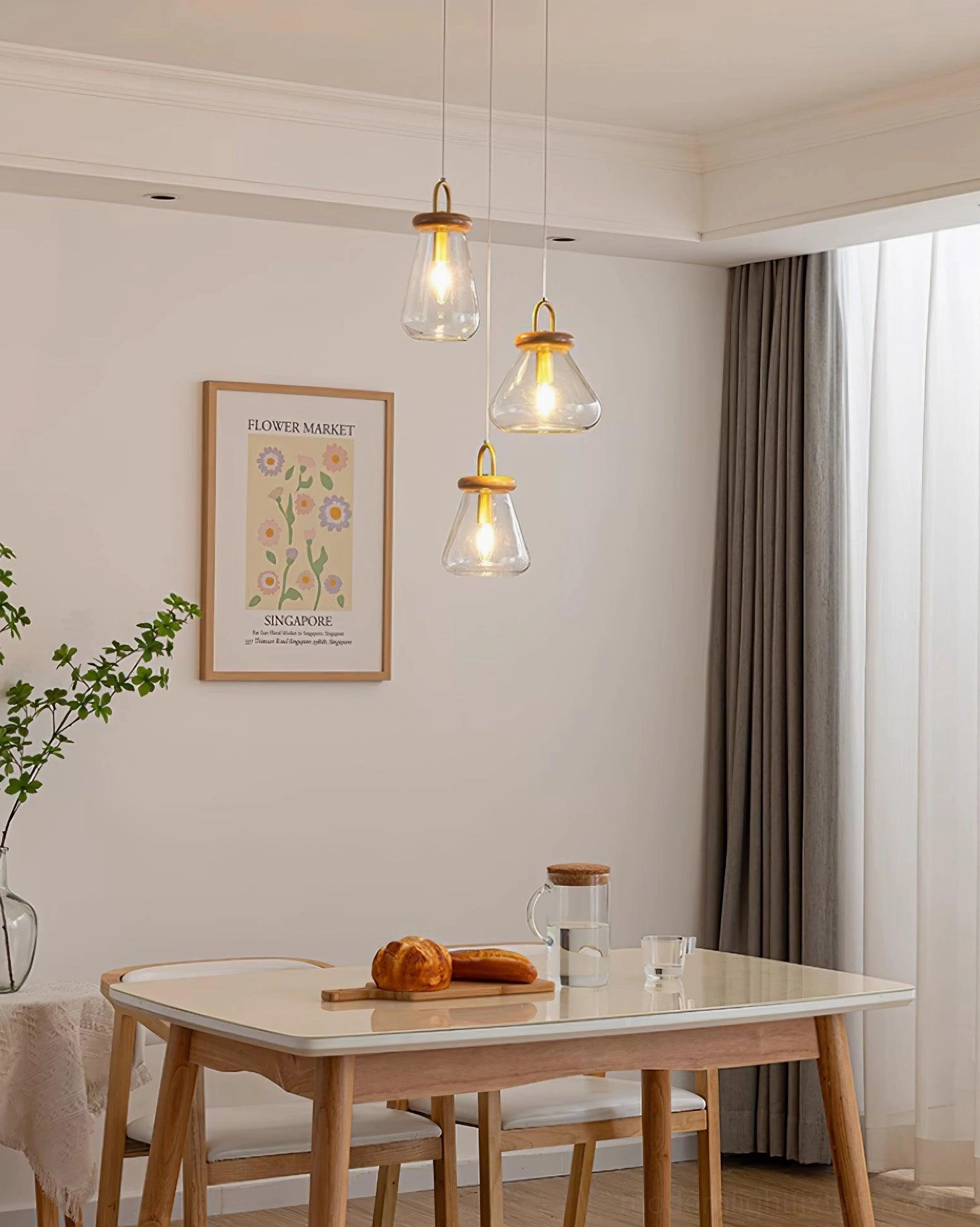 Jar pendant lights with smaller clear glass shades and warm brass finish above modern dining setup