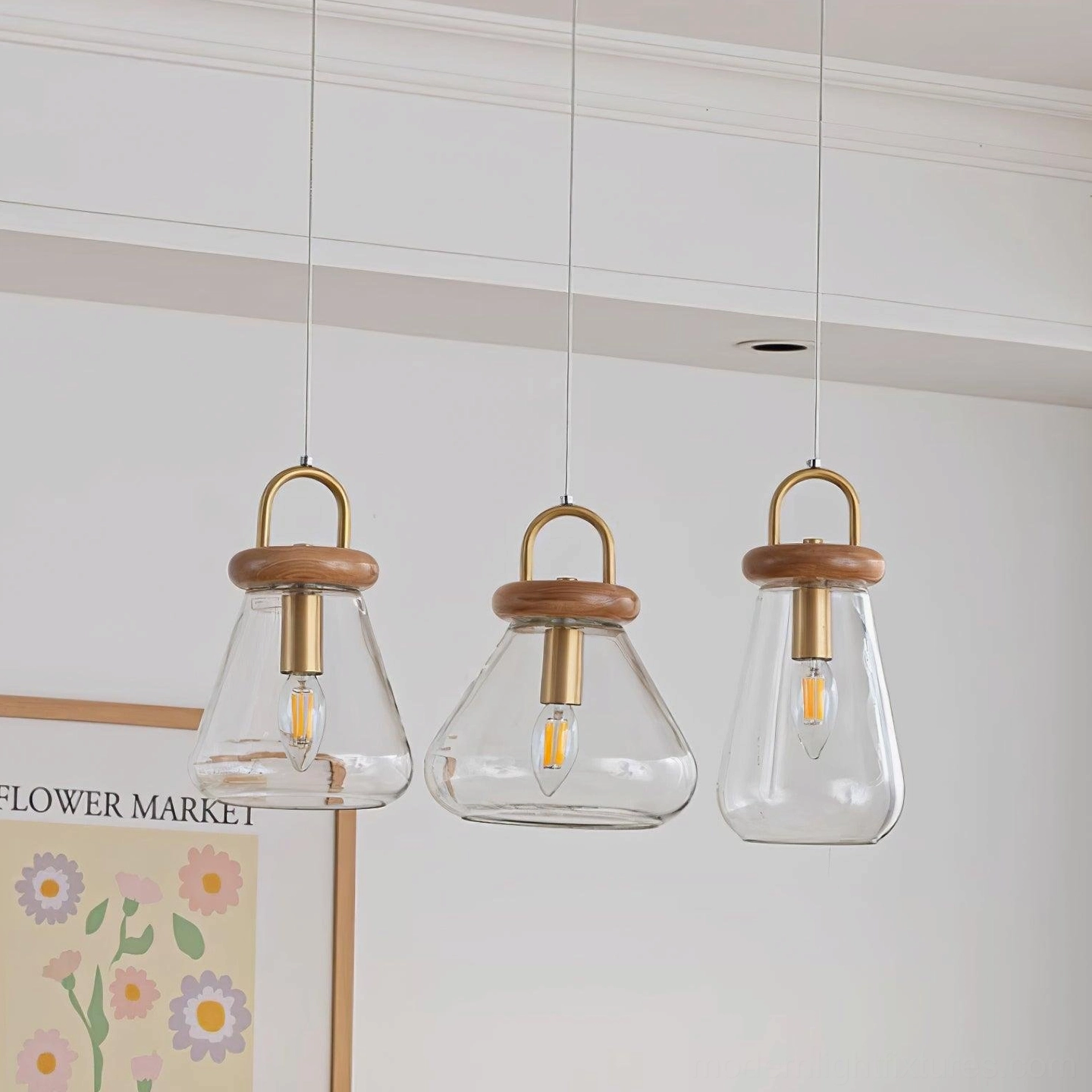 Three jar pendant lights installed at equal heights creating uniform lighting effect in residential corner