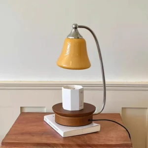 Jaren candle warmer table lamp in three-quarter angle showing chrome curved arm and glass shade detail